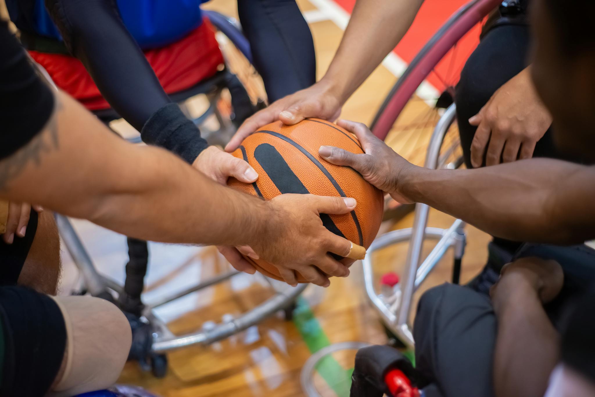 Diverse wheelchair basketball players uniting in teamwork, showcasing cooperation and inclusion.
